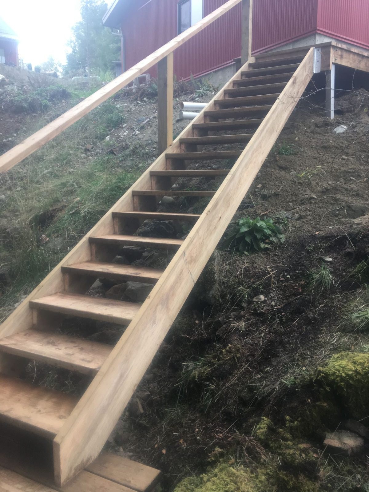 Long finished cedar staircase with timber railing descending toward the waterfront on Quadra Island