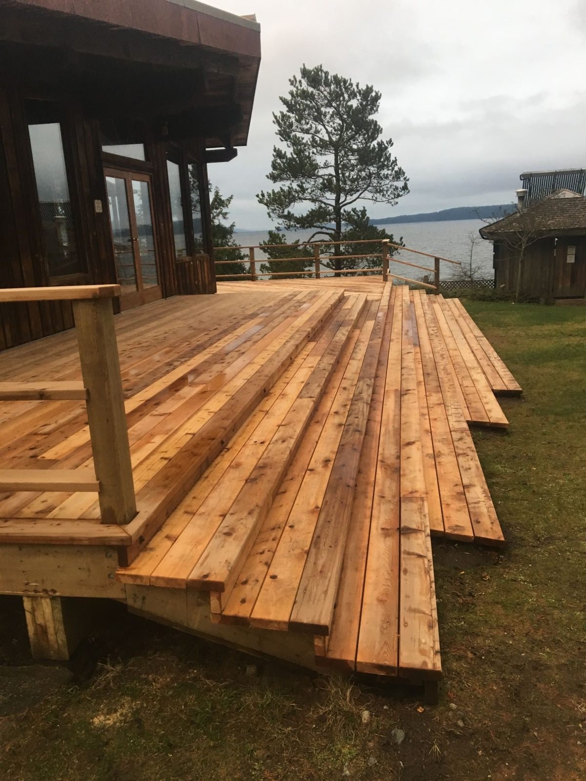Multi-level cedar deck with tiered platforms and railing on Quadra Island