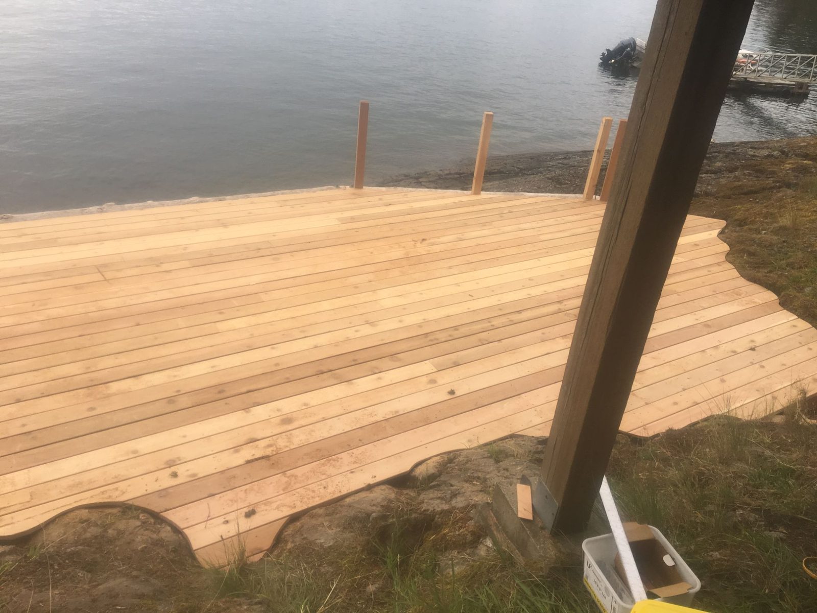 New cedar deck under construction at the waterfront with railing posts set and ocean view