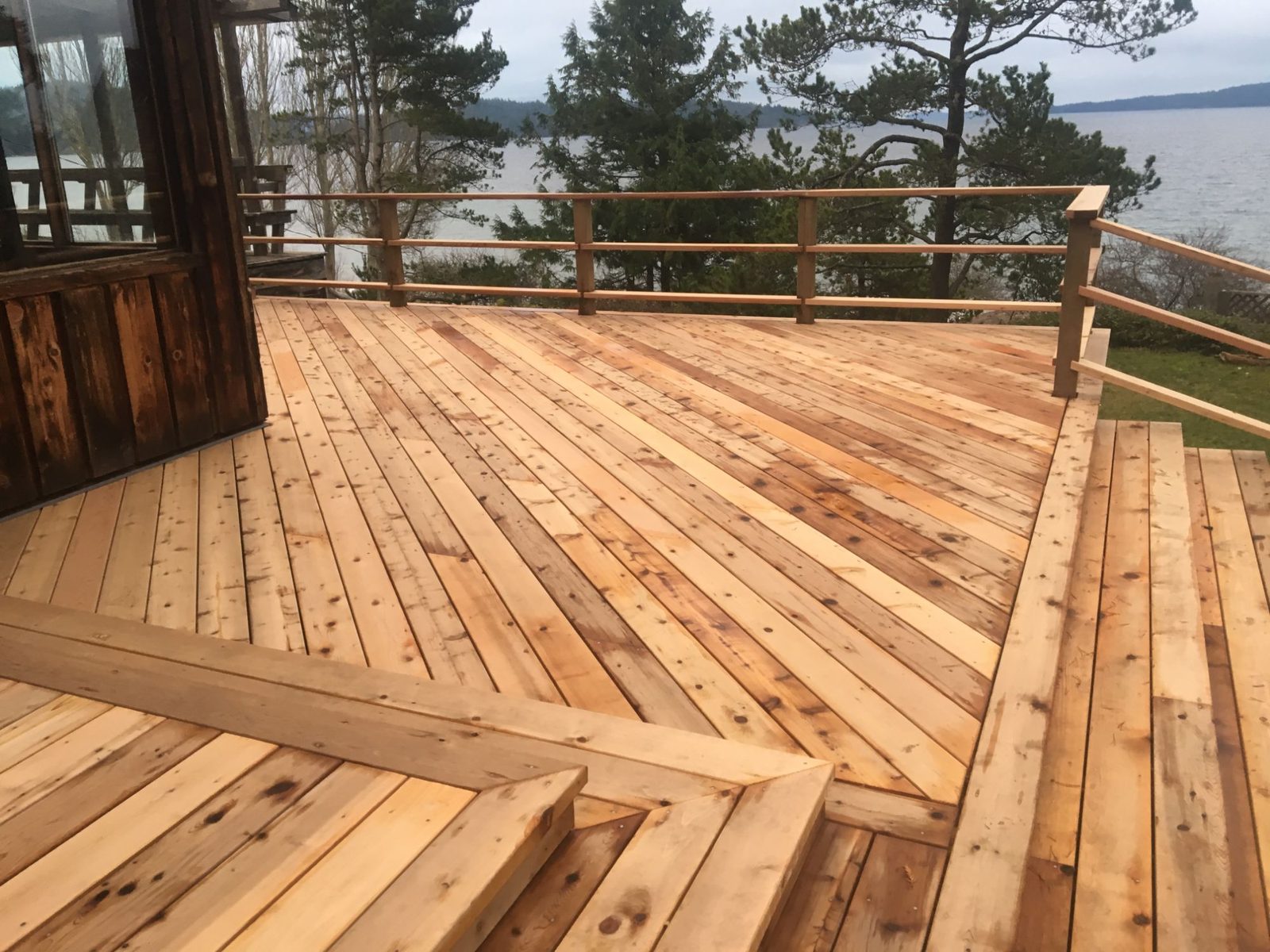 Spacious cedar deck with bench and railing overlooking the ocean on Quadra Island