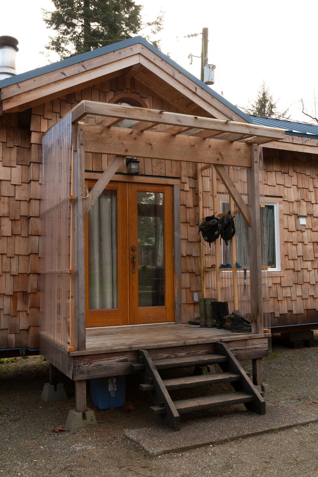 Cedar shingle tiny home with covered porch, French doors and wood steps on Quadra Island